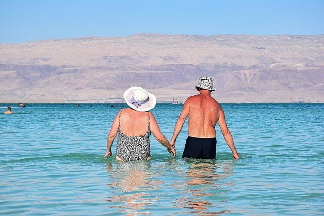 老夫婦が手をつなぎ海を歩く
