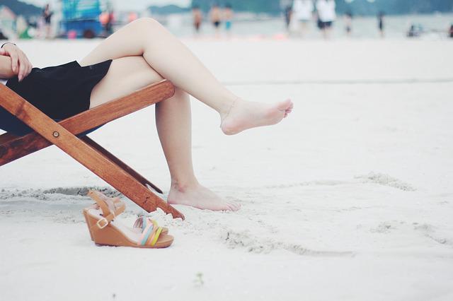 浜辺で足を組む女性